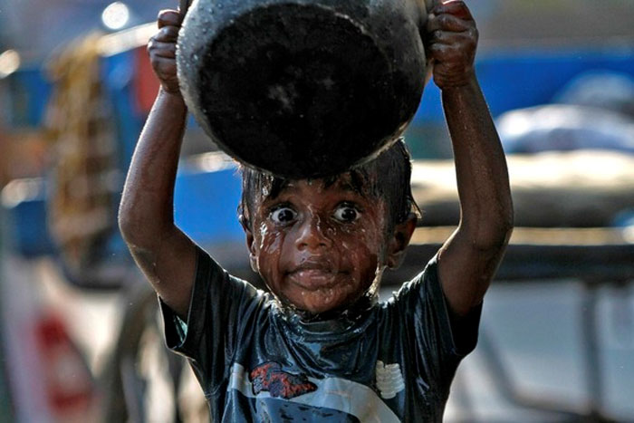 Можда је вода мало прехладна?
Дјечак се пере  тако да се полијева водом из ћупа у јужном индијском граду Chennai.  Што је узрок његовом чуђењу тешко је претпоставити, но можда је ријеч о изнанеђењу због хладне воде.