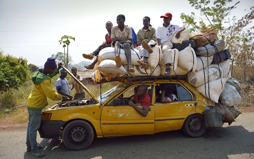 Човјек провјерава мотор таксија, који треба да превезе људе око 50 км сјеверно од главног града Централне Афричке Републике, на пијацу како би продали своје производе...