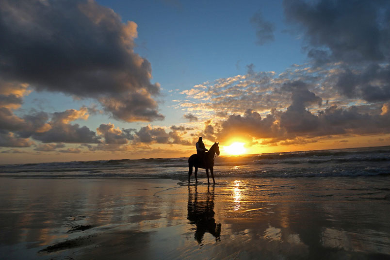 Човјек из Палестине  јаше коња у залазак Јабалииа плажи у појасу Газе