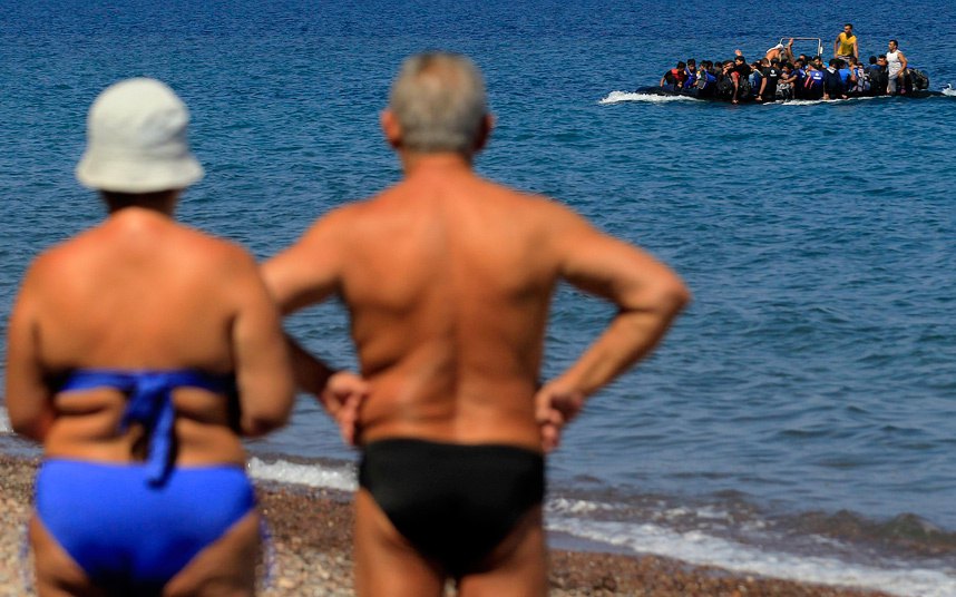 Купачи посматрају избјеглице из Сирије који су из Турске пристигли на обале градића Митилинија на Грчком острву Лесвос...