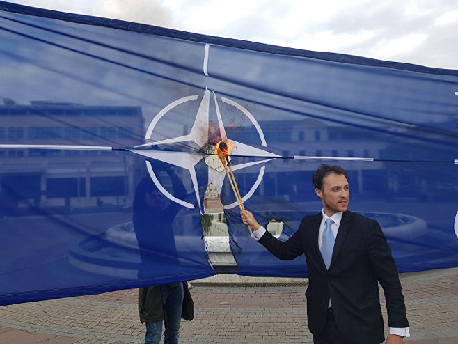 Марко Милачић пали заставу НАТО-а (Фото: Sputnik / Небојша Поповић) - 