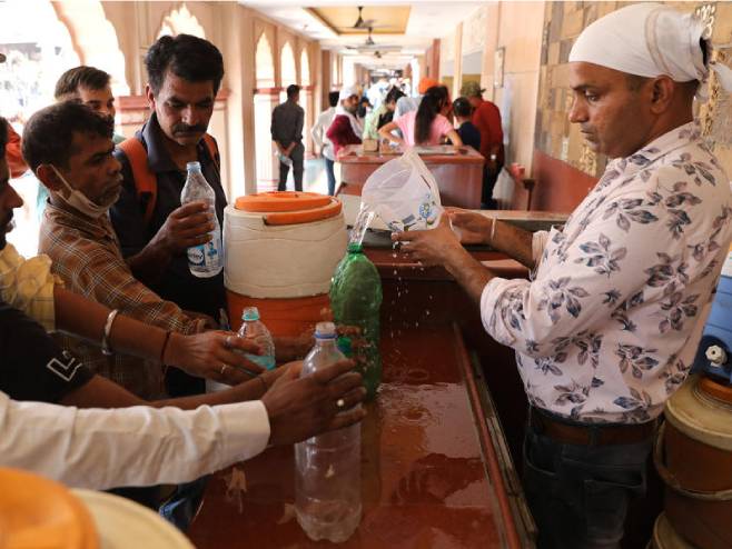 Волонтер дијели воду грађанима (Фото: EPA-EFE/RAJAT GUPTA) - 